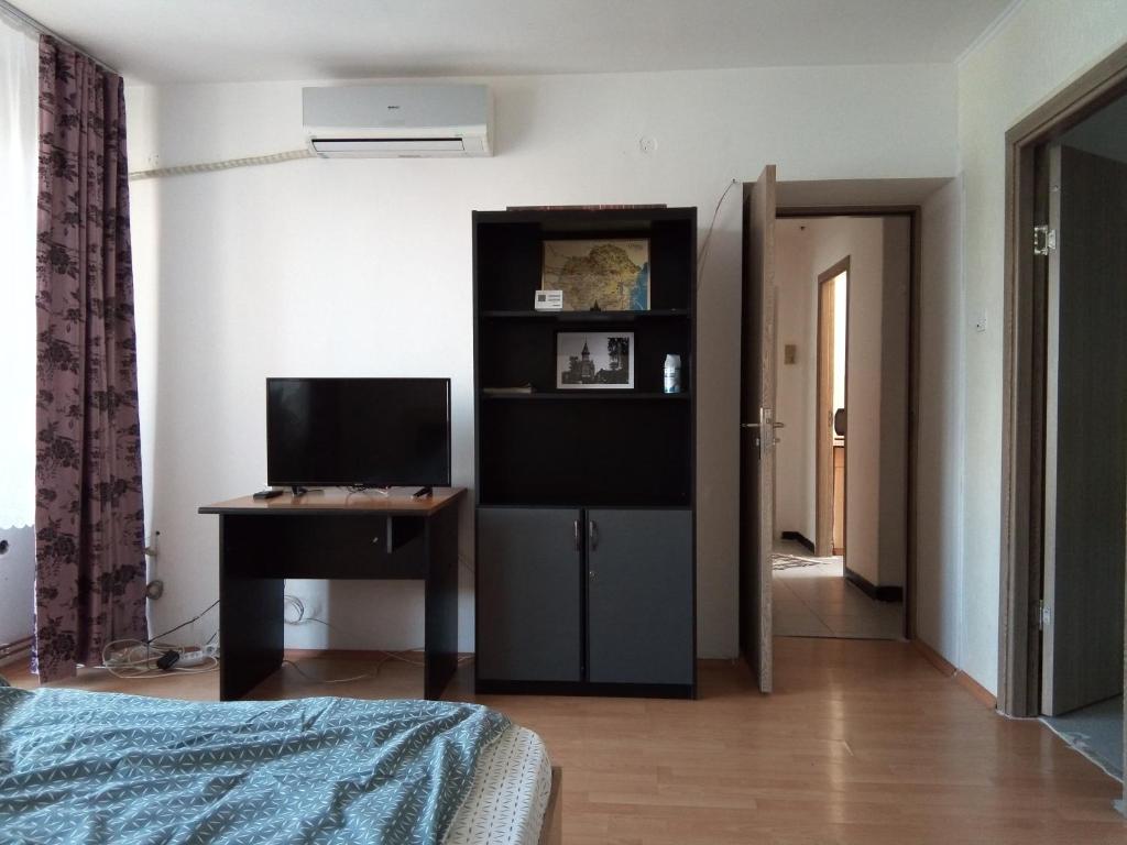 Zimmer mit einem Bett, einem Schreibtisch und einem Computer in der Unterkunft Central Apartment 2 in Timişoara