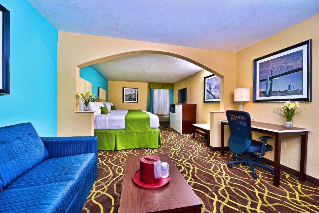 Best Western Plus Savannah Airport Inn and Suites في سافانا: غرفه فندقيه بسرير واريكه