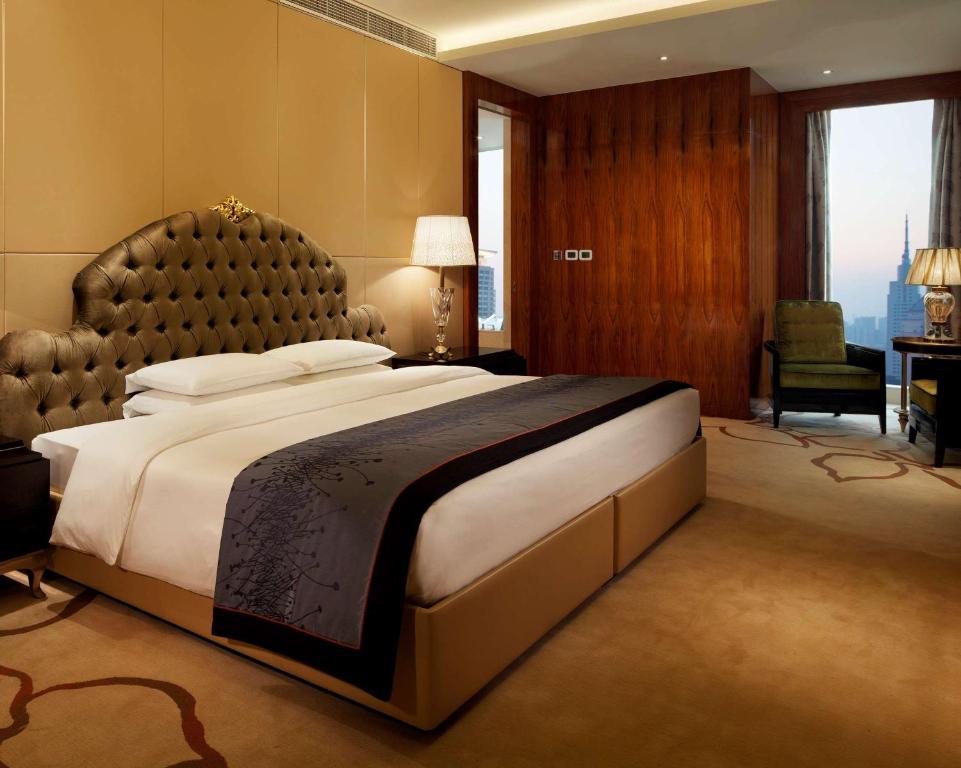a large bedroom with a large bed with a large headboard at Hyatt Regency Jinan in Jinan