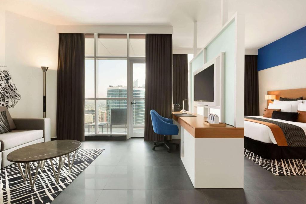 a hotel room with a bed and a desk at TRYP by Wyndham Dubai in Dubai
