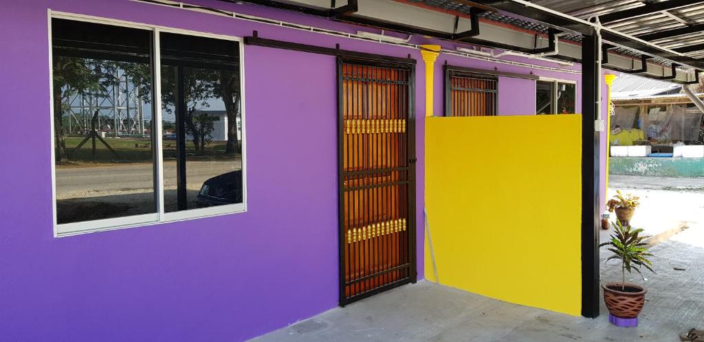 een paarse en gele gevel van een gebouw met ramen bij Homestay Che Kiah in Kuantan