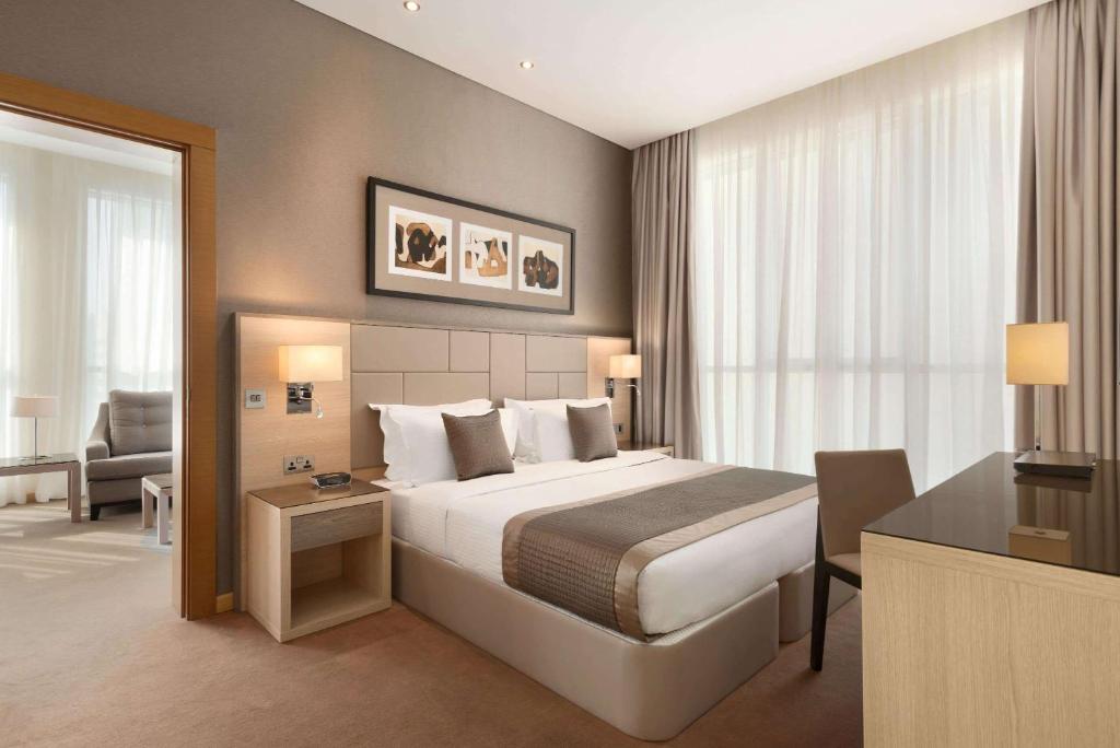 a hotel room with a bed and a desk at TRYP by Wyndham Abu Dhabi City Center in Abu Dhabi