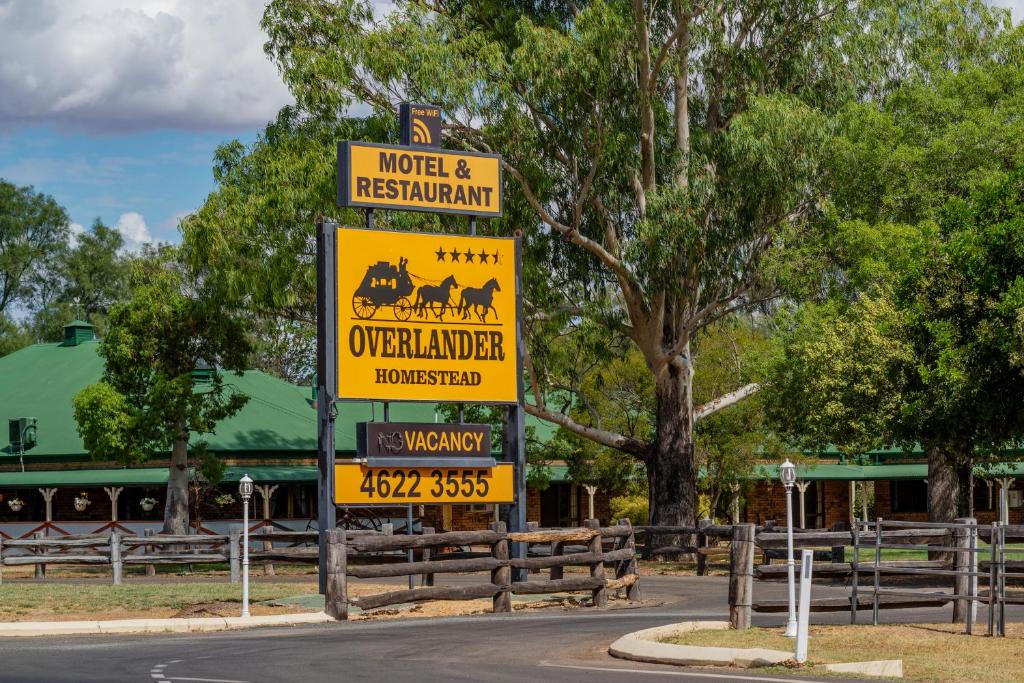 una señal al costado de una carretera en Overlander Homestead Motel, en Roma