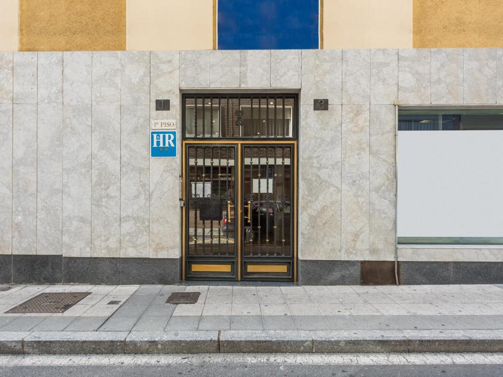 una puerta en el lateral de un edificio en Hostal Uría, en Salamanca