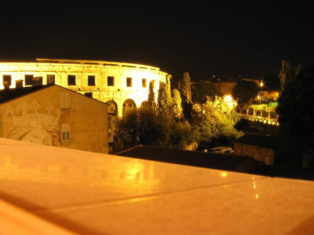 a view of a building at night at Terrace Dream View over Amphitheatre in Pula