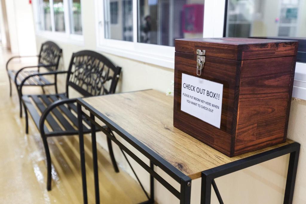 A communal table and chairs beside a wooden check-out box.