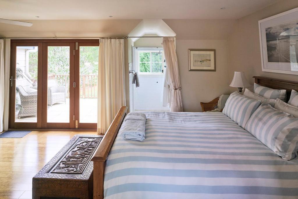 a bedroom with a large bed and a sliding glass door at The Willows at Kurrajong in Kurrajong