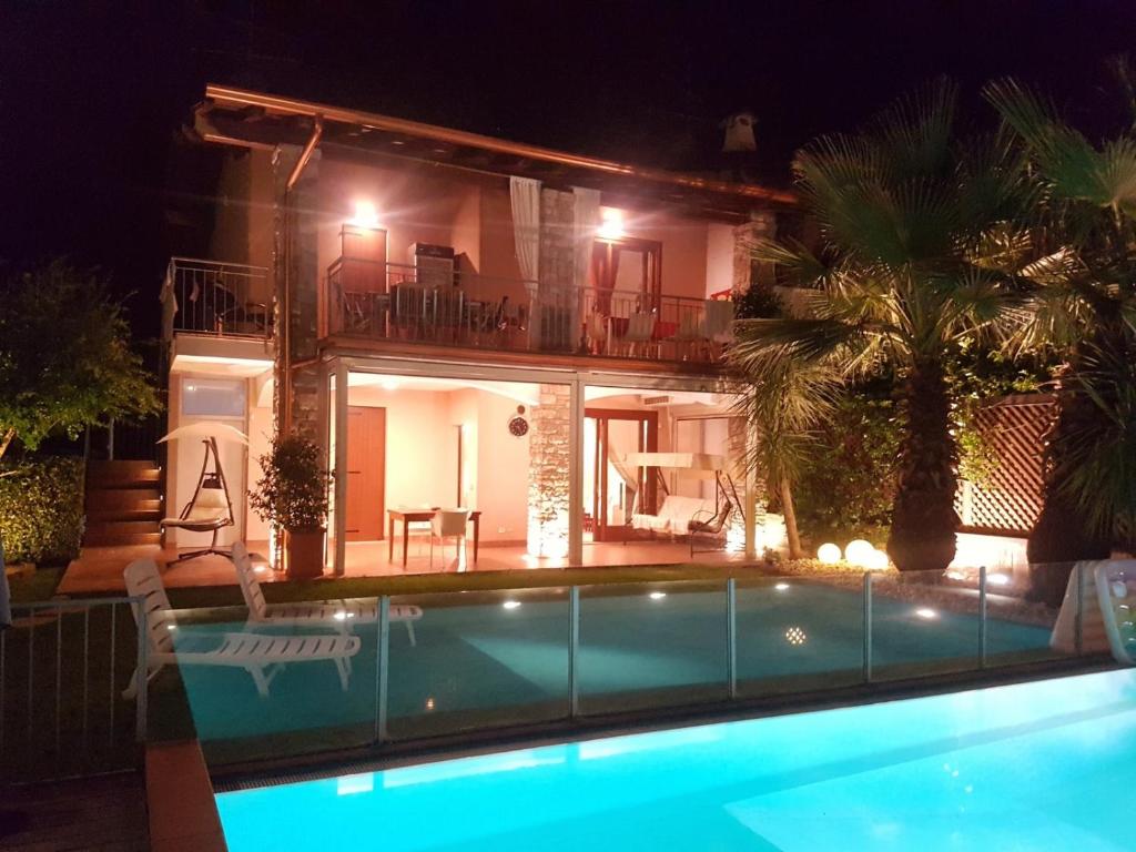 a villa with a swimming pool at night at Casa Camilla in Polpenazze del Garda