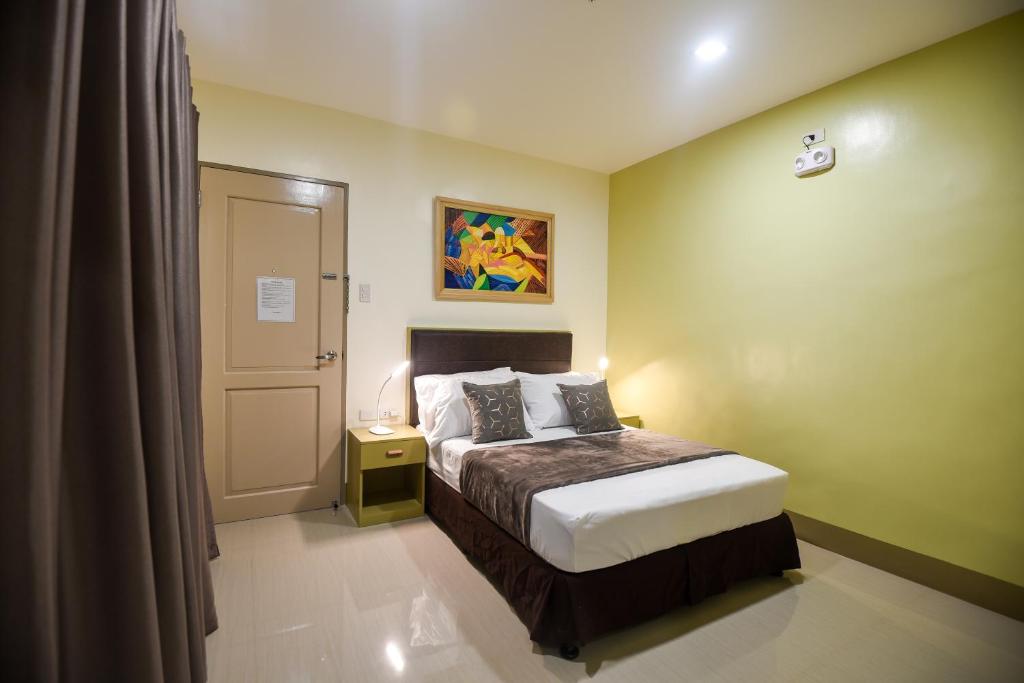 a small bedroom with a bed and a door at ETT HomeTel in Kalibo