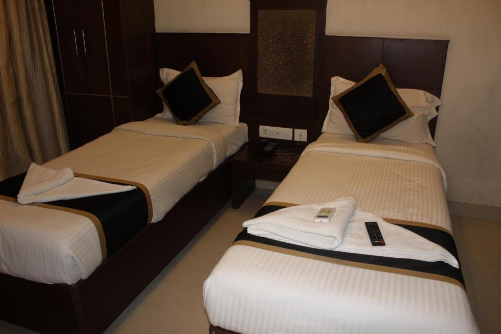 Postel nebo postele na pokoji v ubytování SKY GATE HOTEL Near Apollo MAIN, Women's & Children's US Consulate Sankara Netralaya Goethe Institute PrestigePalladium Shastri Bhavan Senmozhi Poonga Raj Ratnam Stadium TAJ Coromandal India Oil Bhavan Dr Mohan's Diabetics VAC Chennai