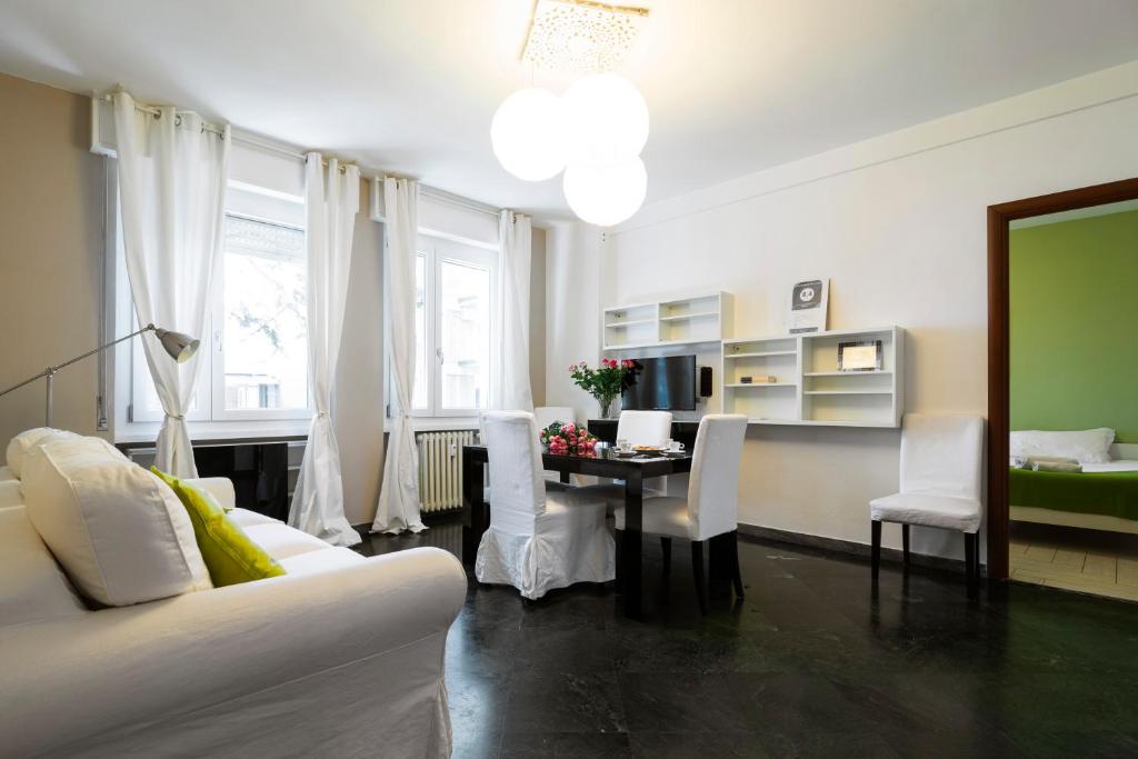 uma sala de estar com uma mesa e cadeiras brancas em Milanocity MICO MIART em Milão