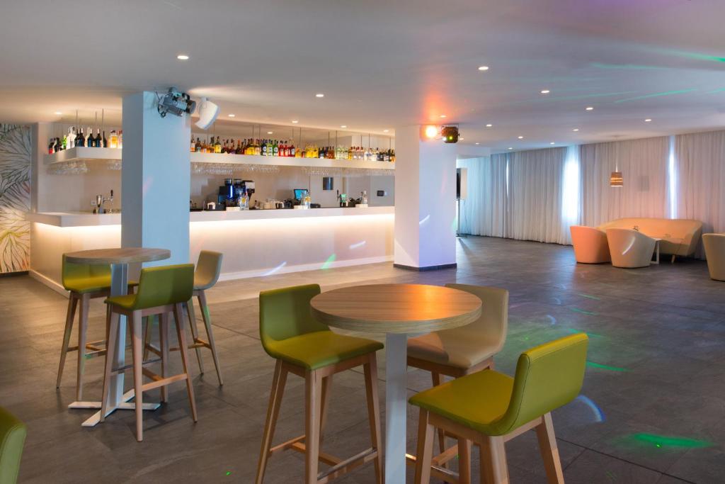 a restaurant with a table and chairs and a bar at Iberostar Selection Lanzarote Park in Playa Blanca