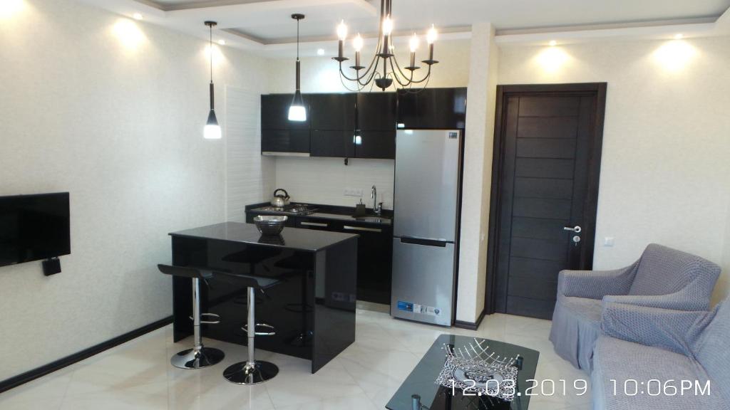 a kitchen with a black counter and a refrigerator at Orbi Plaza 4 & New Boulevard in Batumi