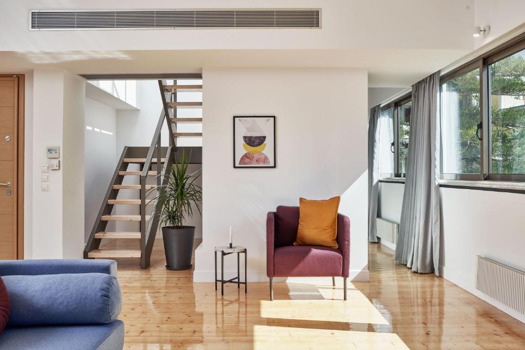 Sala de estar con silla morada y escaleras en MONO Lofts, en Atenas