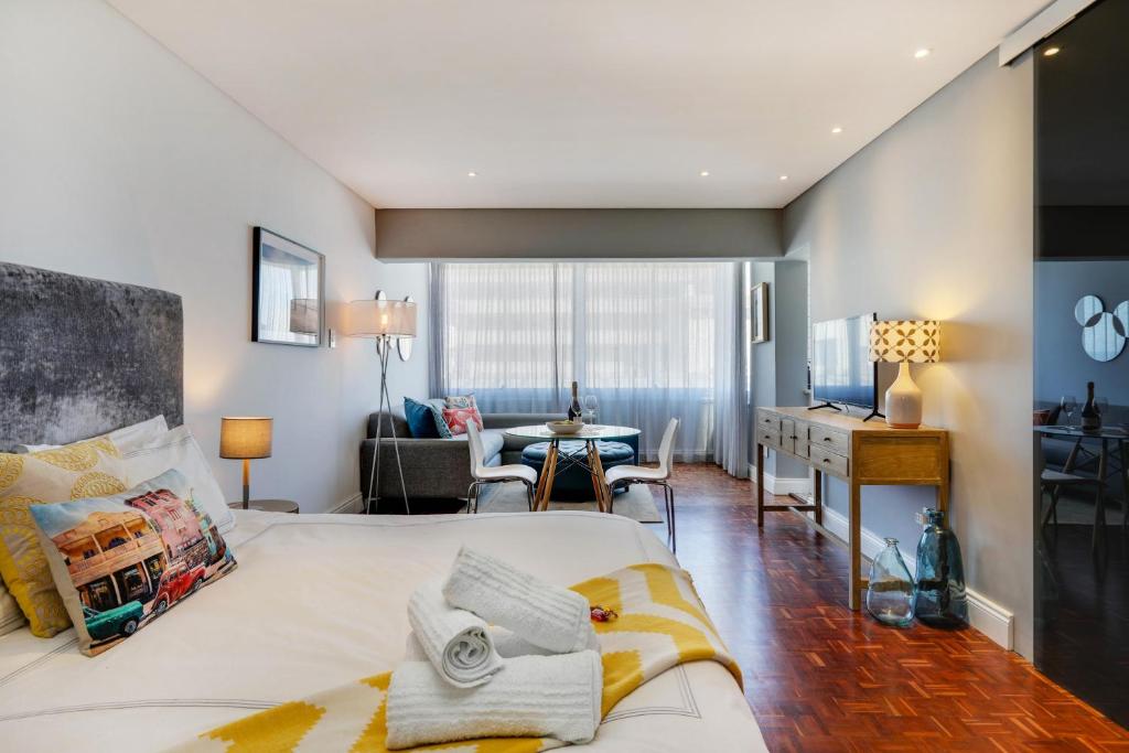 a bedroom with a bed and a living room at Backup-Power Mouille Point Apartment in Cape Town