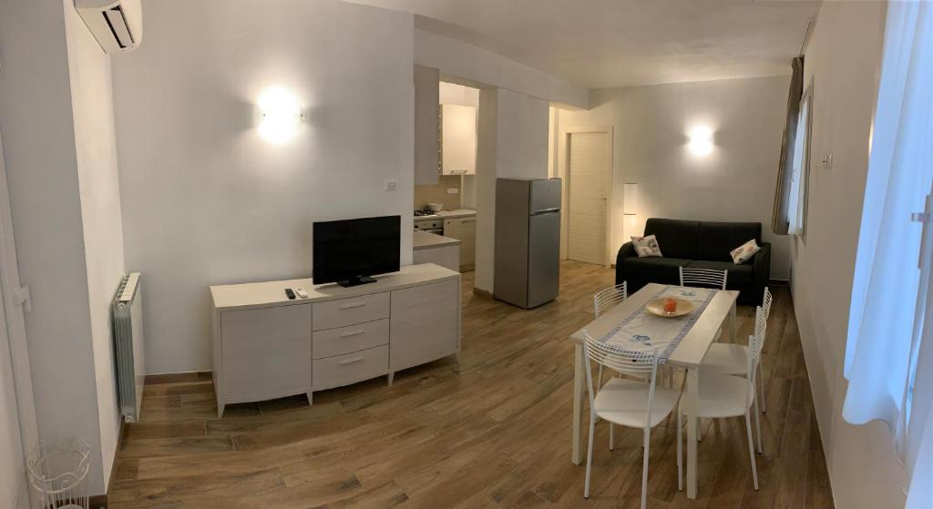 un soggiorno con un divano e un tavolo con una televisione di Ca du Sergio - Le Mura a Levanto