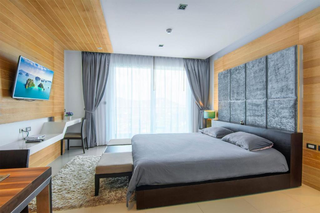 a bedroom with a bed and a desk and a sink at Emerald Terrace Resort in Patong Beach