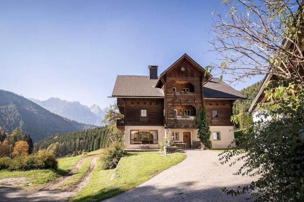 een groot houten huis op een heuvel in de bergen bij Almurlaub Buchebnerreith, Ferienwohnungen in Hinterstoder