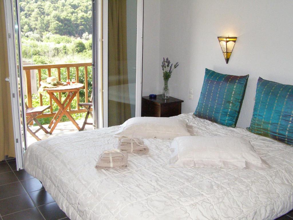 a bedroom with a bed and a balcony with a table at To Ktima tis Matinas in Stafylos