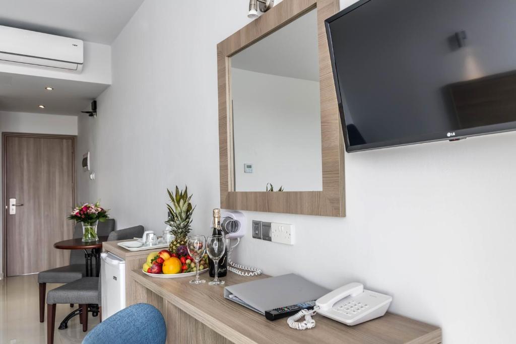 a kitchen with a counter with a television on a wall at Bellini Hotel in Ayia Napa