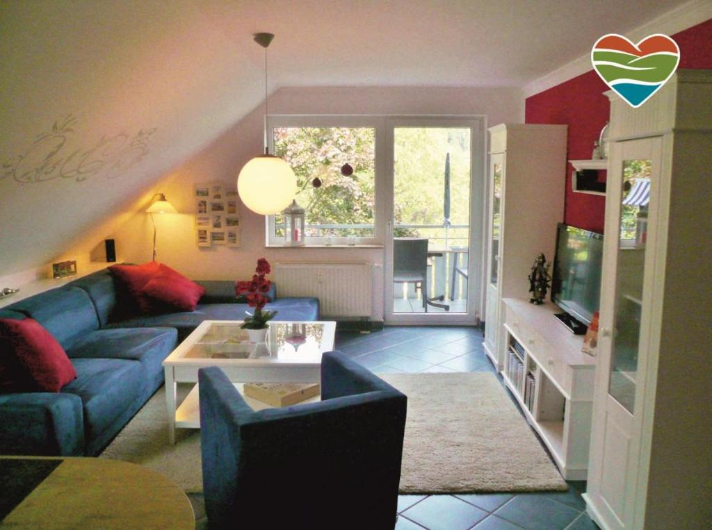 sala de estar con sofá azul y TV en Fewo C am Kurpark mit MeineCardPlus en Willingen