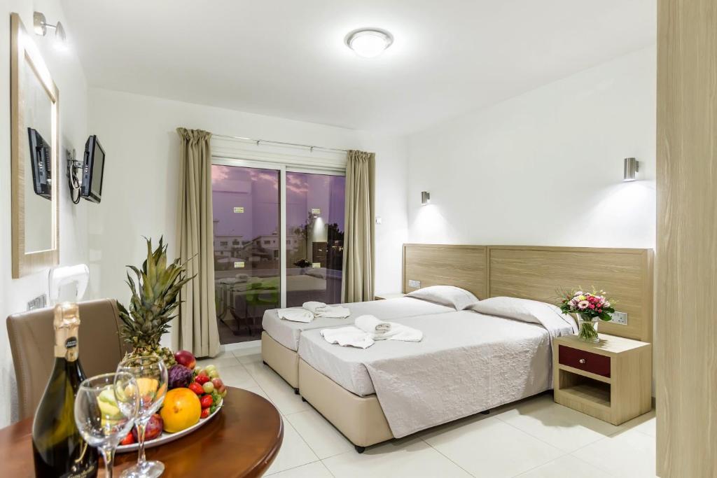 a bedroom with a bed and a table with a bowl of fruit at Bellini Hotel in Ayia Napa