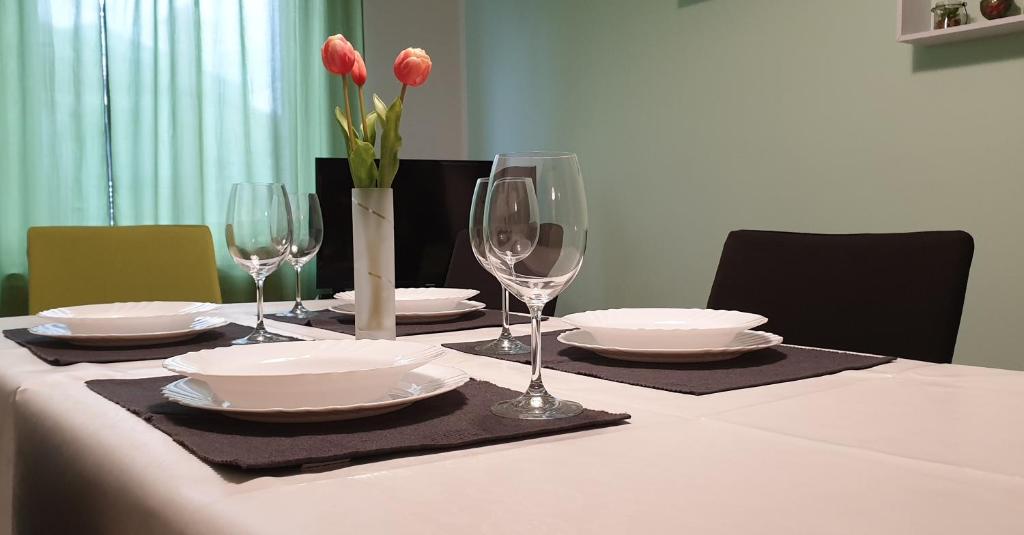 a table with wine glasses and plates and flowers on it at Lovely apartment in Pomer in Pomer