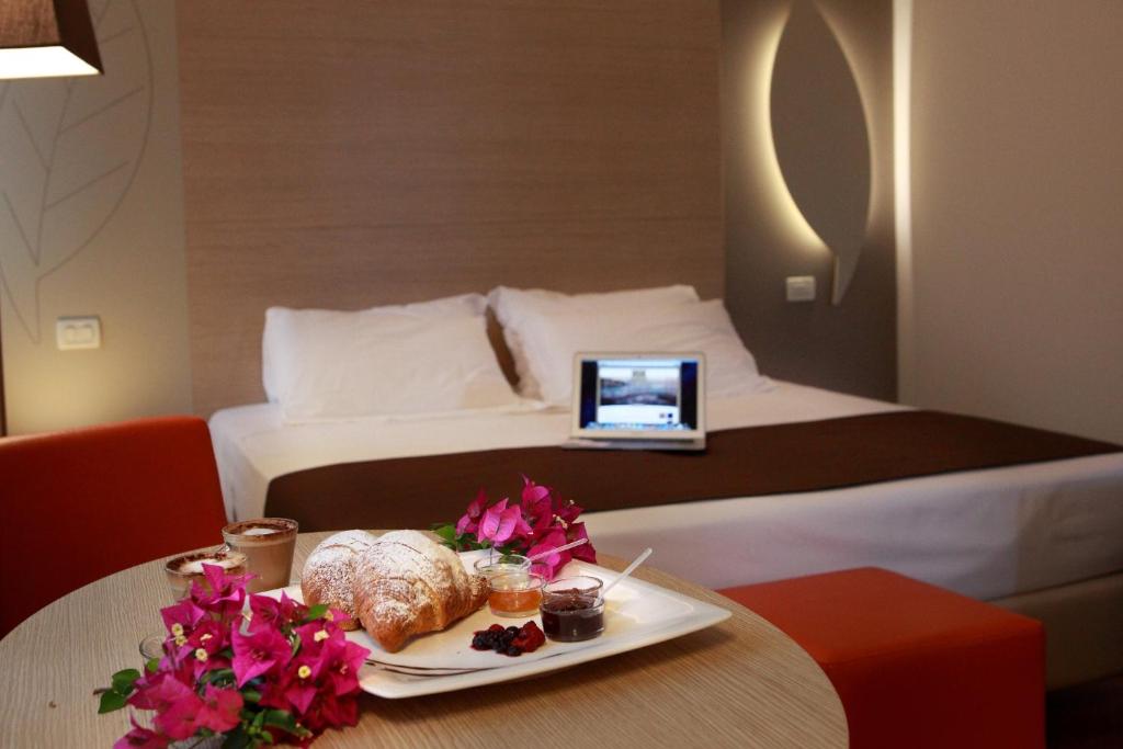 pokój hotelowy z łóżkiem i tacą z jedzeniem na stole w obiekcie Hotel Colonne w mieście San Giovanni Rotondo