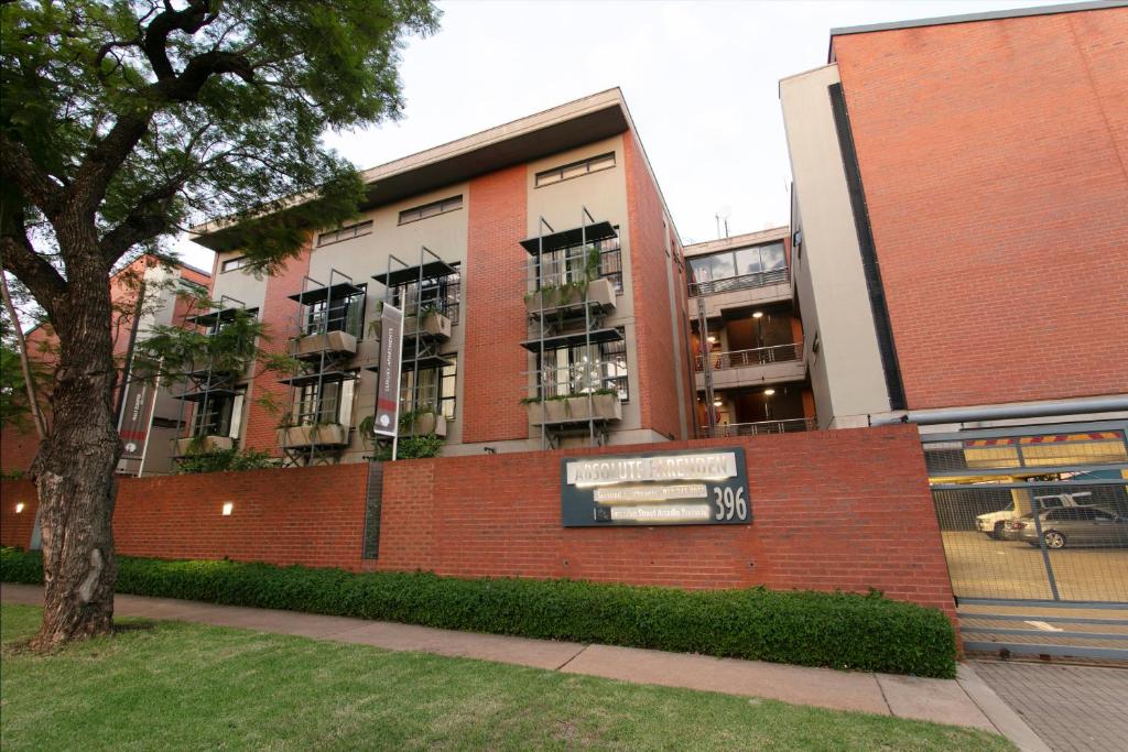 a brick building with a sign in front of it at Absolute Farenden Apartments in Pretoria