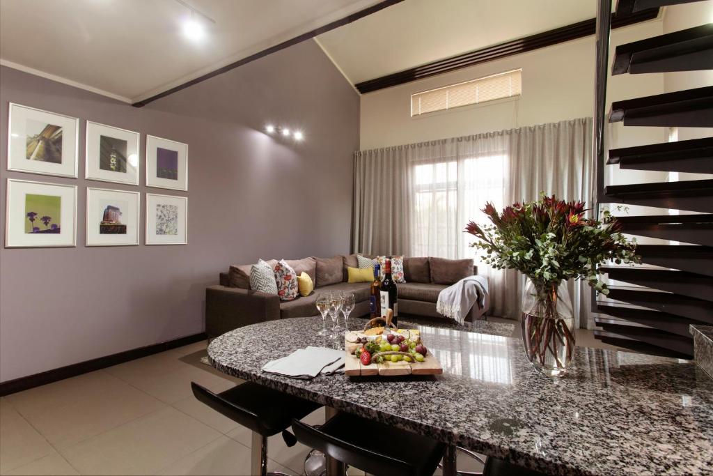 a living room with a table and a couch at Absolute Farenden Apartments in Pretoria