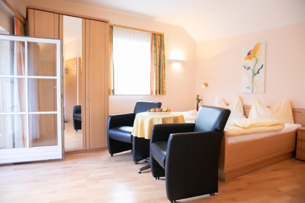 une chambre d'hôtel avec un lit, des chaises et une table dans l'établissement Weisses Lamm, à Hallstatt