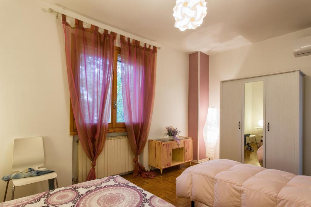 una camera con letto e finestra con tende di Casa Renalda a Gradara