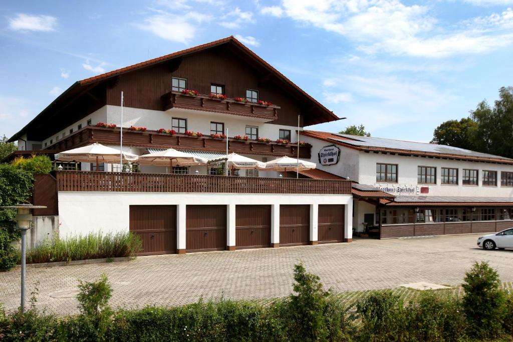 un grand bâtiment avec deux portes de garage et une voiture dans l'établissement Spirklhof, à Bodenkirchen