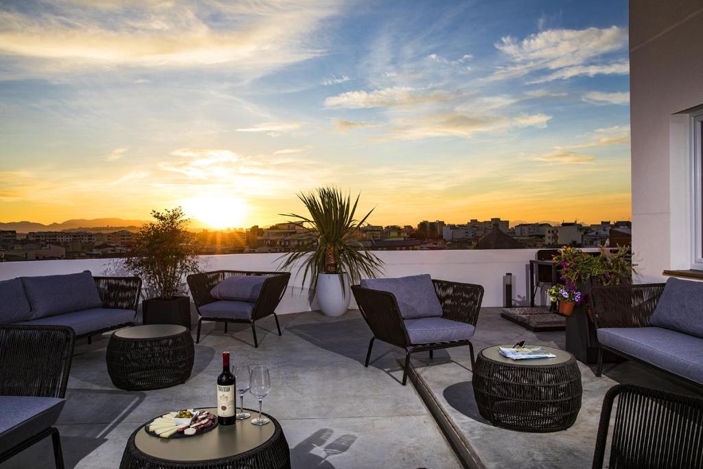 a patio with couches and chairs and a sunset at Milestone in Quartu SantʼElena