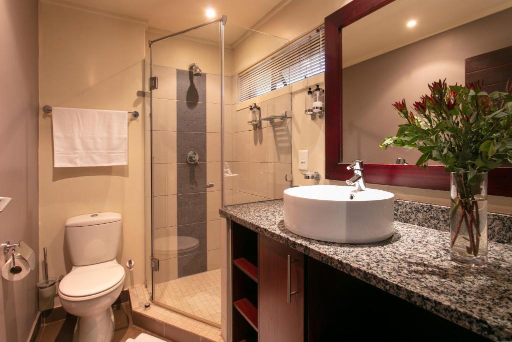 a bathroom with a sink and a toilet and a shower at Absolute Farenden Apartments in Pretoria
