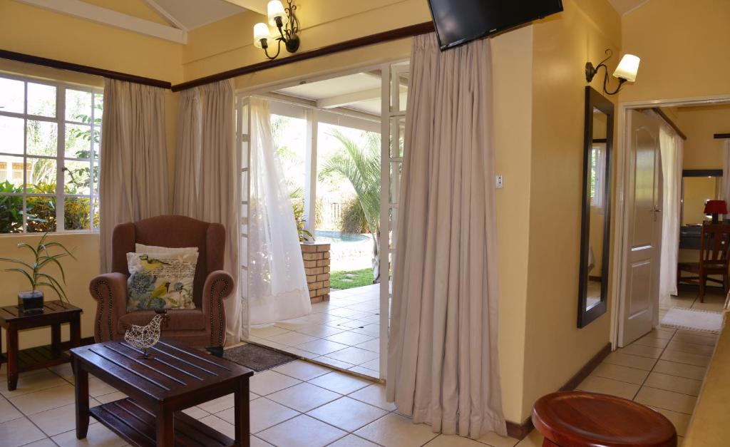 a living room with a door leading to a patio at Chobe River Cottages in Kasane