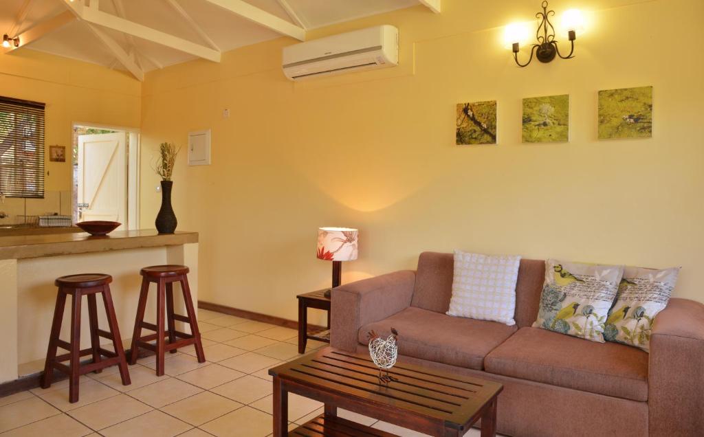 a living room with a couch and a table at Chobe River Cottages in Kasane