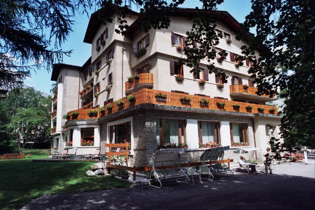 un grande edificio con sedie di fronte di Hotel Des Geneys a Bardonecchia