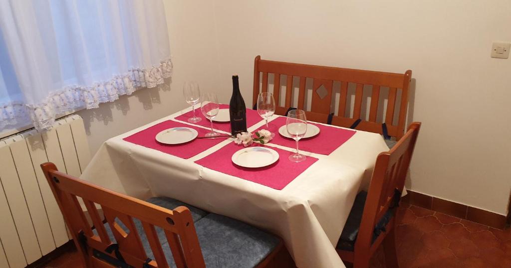 una mesa con mantel blanco y una botella de vino en Sweet apartment in Pomer, en Pomer