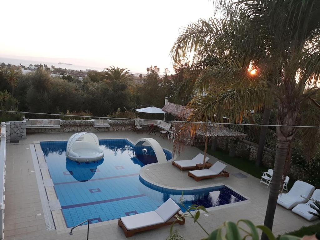 una piscina con due sedie a sdraio e una barca al suo interno di Luxury Country House in Kalamata / SP a Kalamáta
