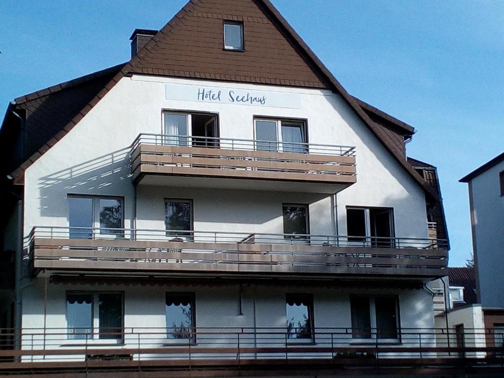 ein hohes weißes Gebäude mit einem Gameradach in der Unterkunft Hotel Seehaus in Horn-Bad Meinberg