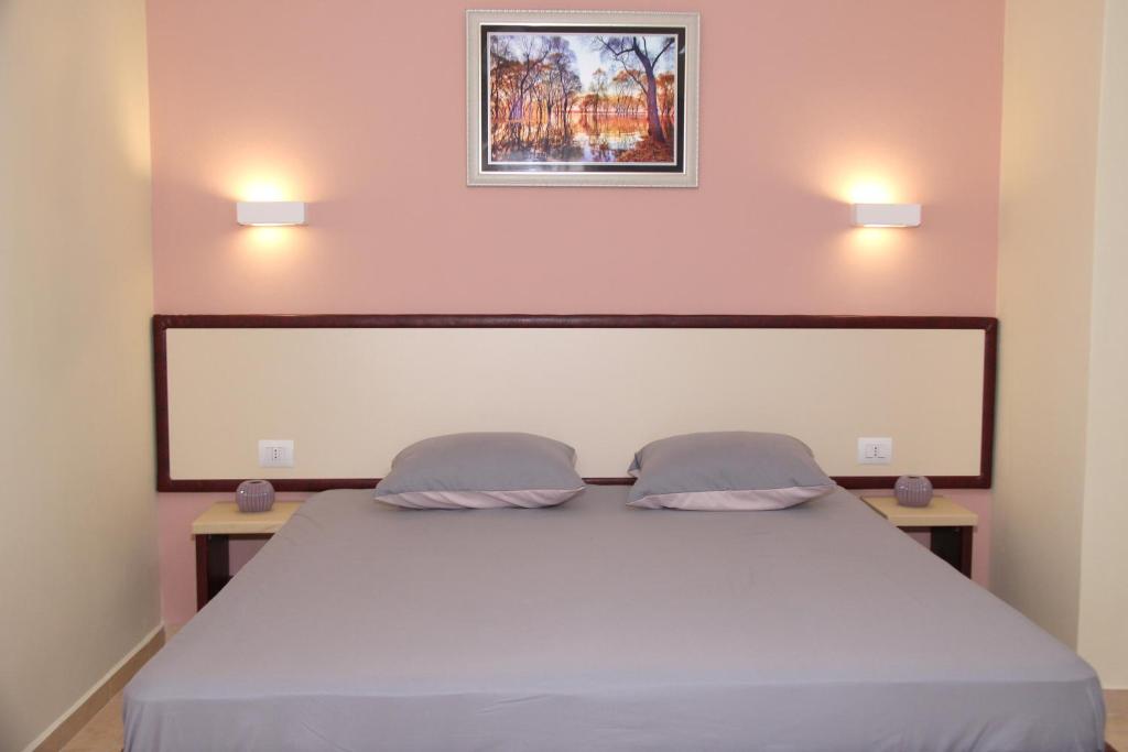 sypialnia z łóżkiem z 2 poduszkami w obiekcie Hotel Ronaldo w mieście Ksamil
