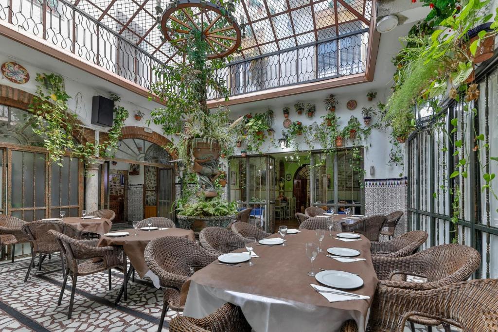 un restaurante con mesas y sillas y techo de cristal en Hotel Las Palmeras by Vivere Stays, en Zafra