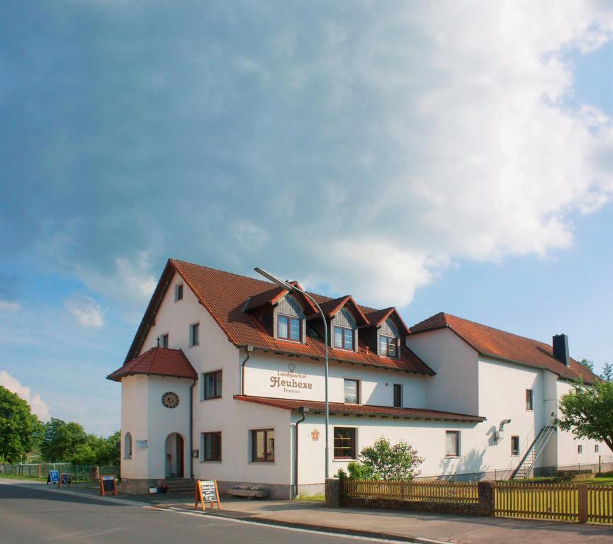 a large white building with a clock on it at Pension Heuhexe in Fladungen