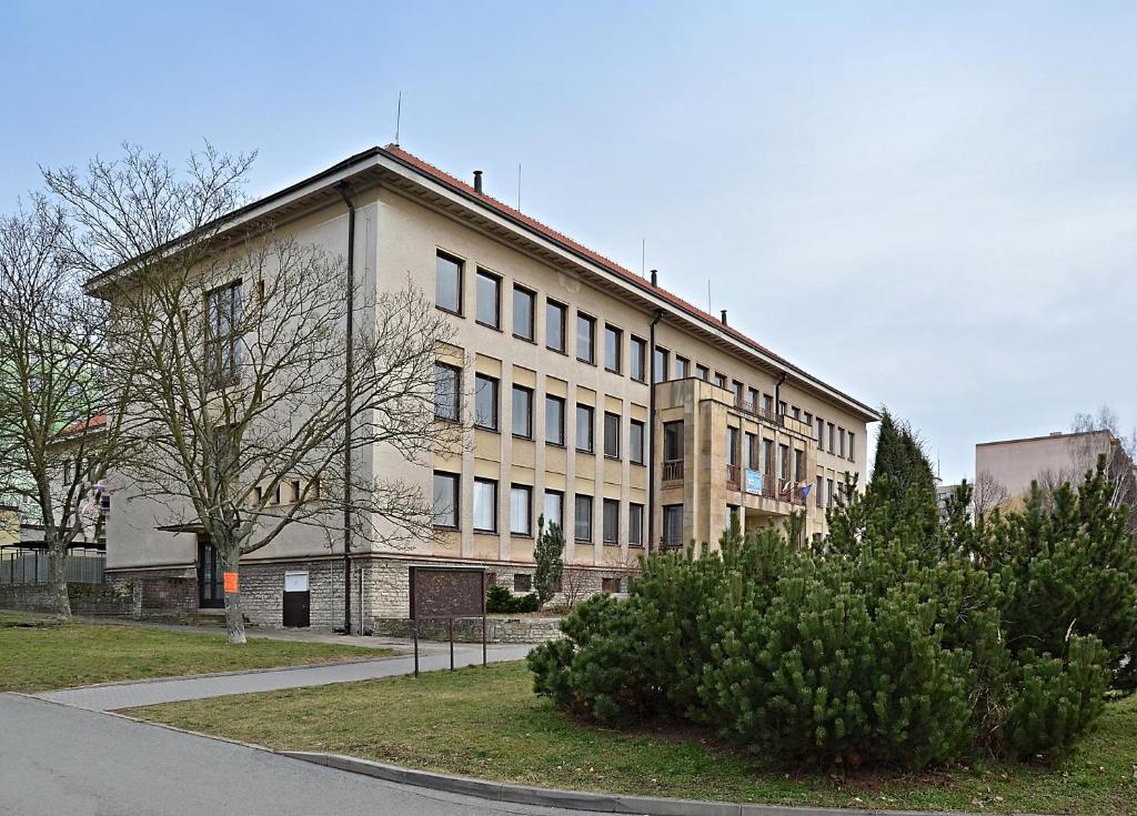 a large building with a tree in front of it at hotel Dobruška in Dobruška