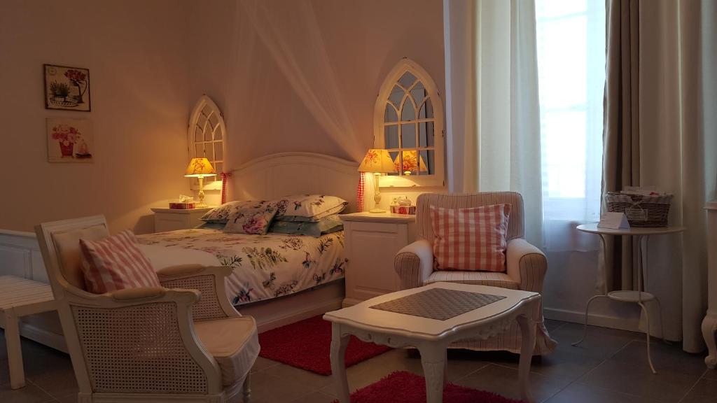 - une chambre avec un lit, deux chaises et une table dans l'établissement Moulin de Cot, à Clermont-lʼHérault