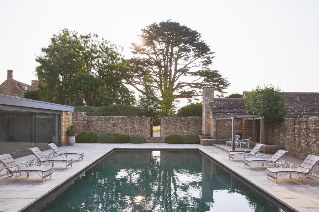 une piscine avec des chaises longues et une terrasse dans l'établissement Thyme, à Lechlade