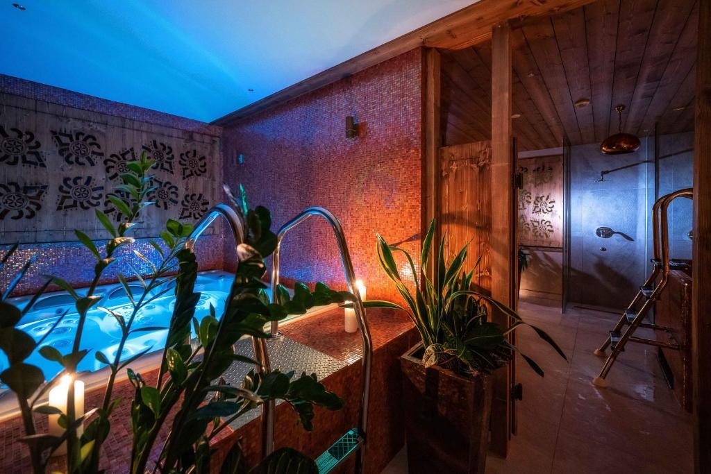 a room with a hot tub with plants in it at Gold Hotel in Zakopane