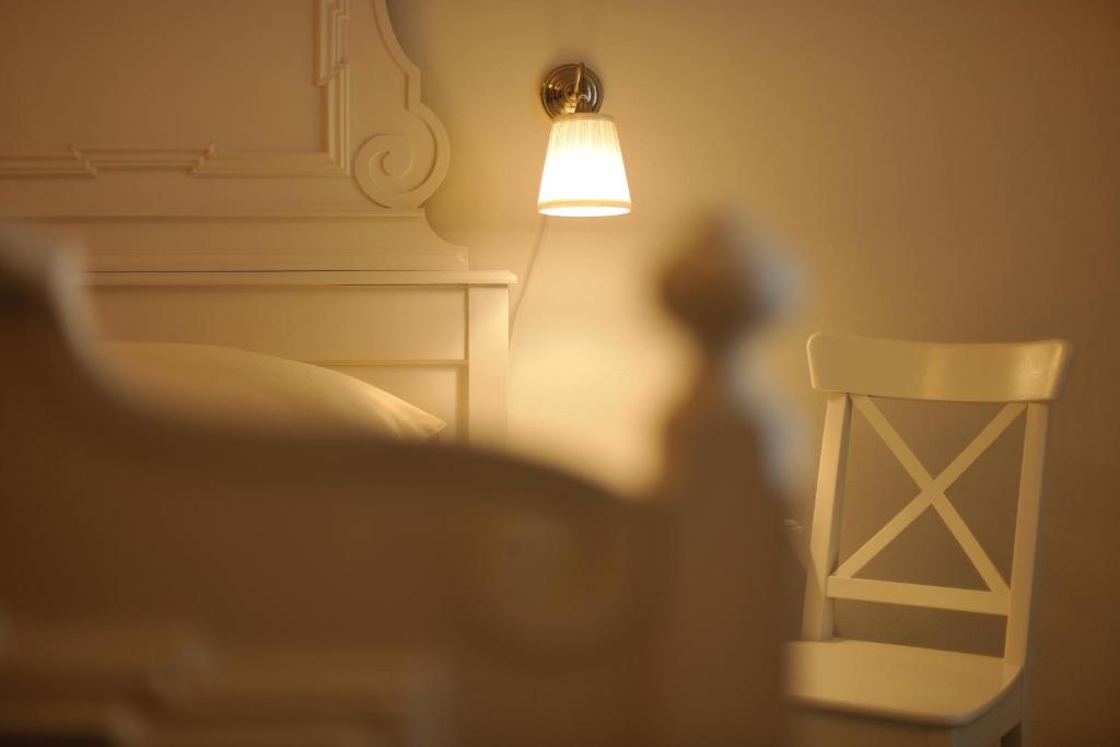 a shadow of a lamp and a chair in a room at Zámek Nové Město nad Metují in Nové Město nad Metují