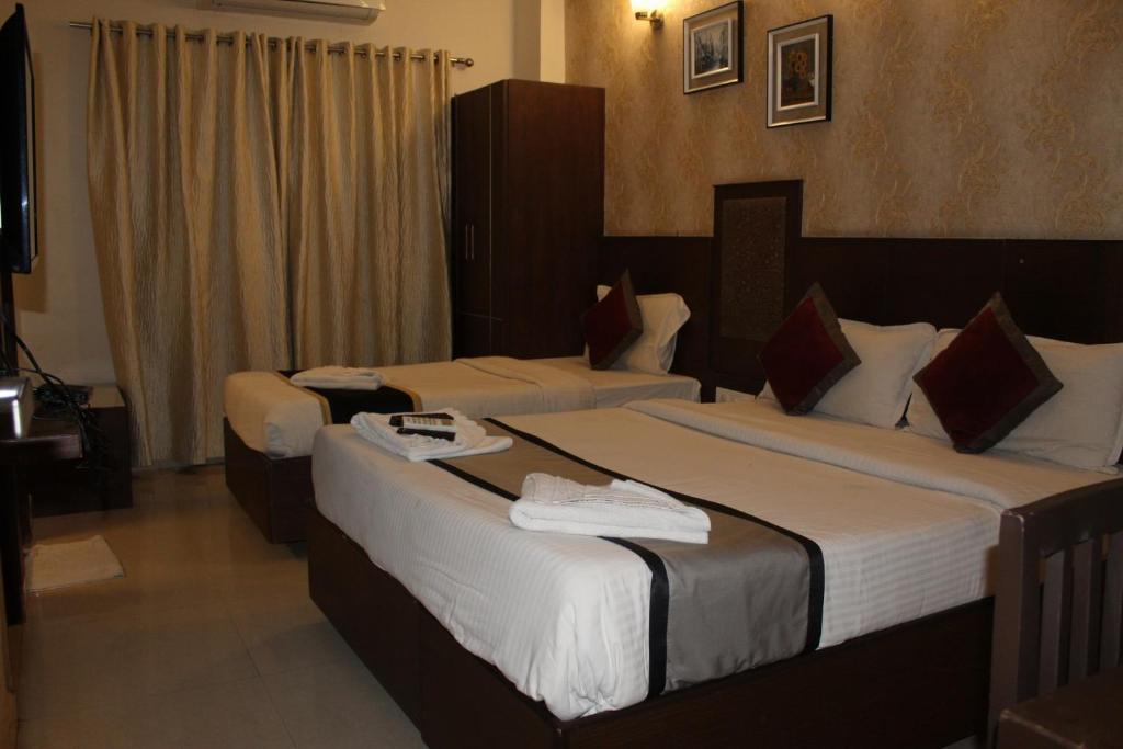 Postel nebo postele na pokoji v ubytování SKY GATE HOTEL Near Apollo MAIN, Women's & Children's US Consulate Sankara Netralaya Goethe Institute PrestigePalladium Shastri Bhavan Senmozhi Poonga Raj Ratnam Stadium TAJ Coromandal India Oil Bhavan Dr Mohan's Diabetics VAC Chennai